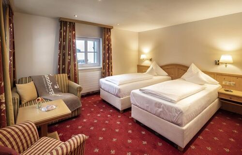 A double room with separate beds and seating
