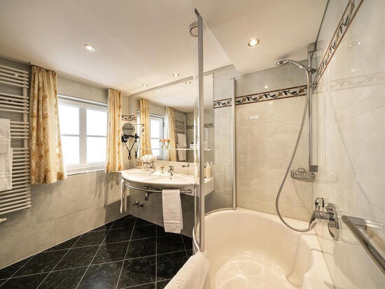 Badezimmer mit schwarzen Bodenfliesen und weißen Wandfliesen