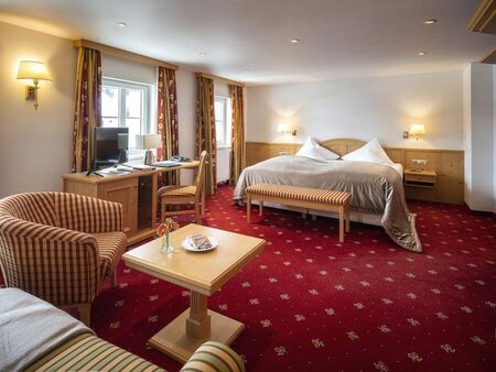 The Deluxe double room with a red carpet and seating
