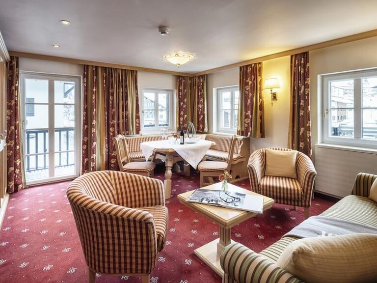 Großes und helles Wohn- und Esszimmer mit Balkon und rotem Teppichboden