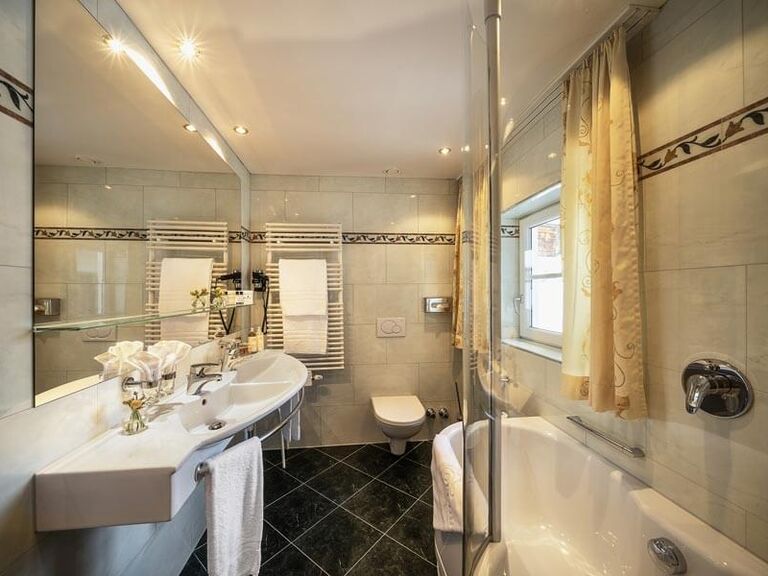 Badezimmer mit Badewanne und Duschwand