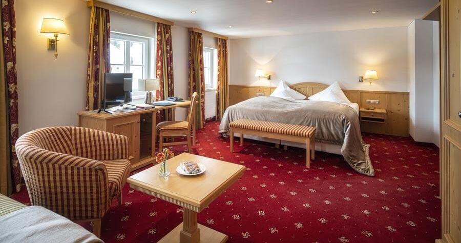 The Deluxe double room with a red carpet and seating