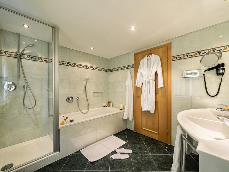 Großes, helles Badezimmer mit Badewanne und Dusche.