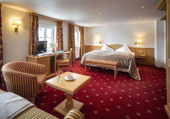 The Deluxe double room with a red carpet and seating