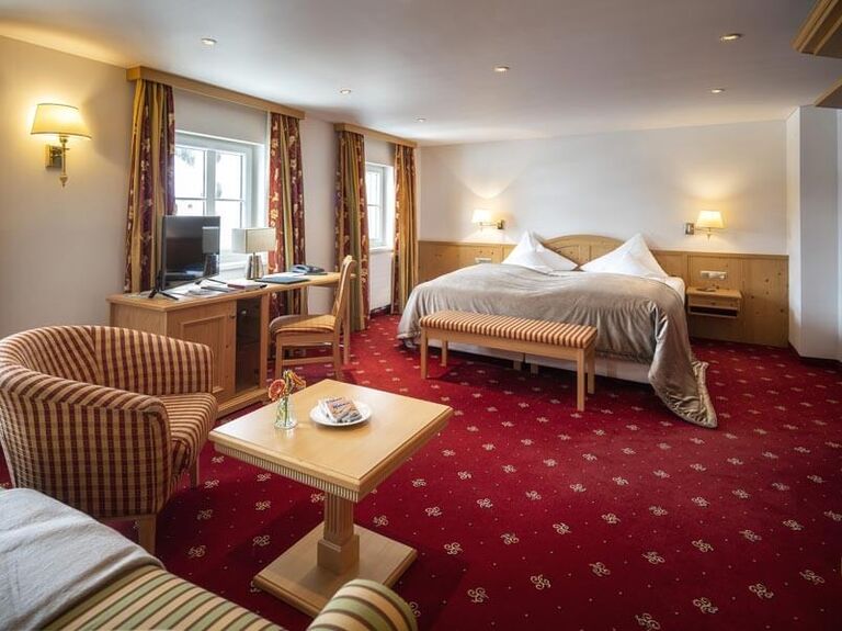 The Deluxe double room with a red carpet and seating