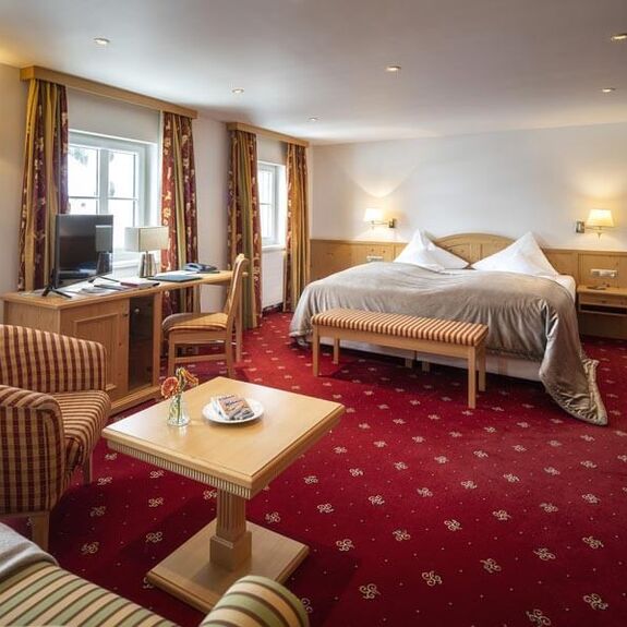 The Deluxe double room with a red carpet and seating