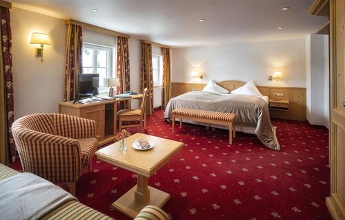 The Deluxe double room with a red carpet and seating