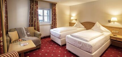Doppelzimmer mit getrennten Betten und Sitzgelegenheit