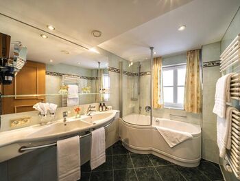 Modernes Badezimmer mit Badewanne und Duschwand