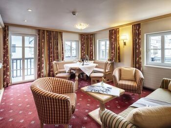 Großes und helles Wohn- und Esszimmer mit Balkon und rotem Teppichboden