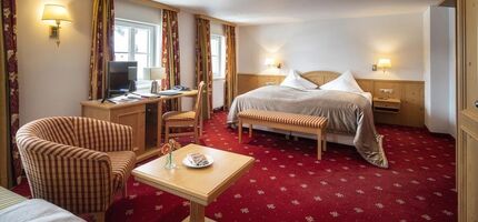 Doppelzimmer Deluxe mit rotem Teppich und Sitzgelegenheit