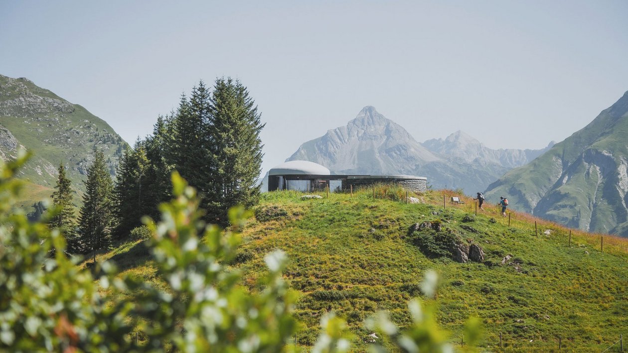 Modern architecture embraced by nature Contemporary structure on a hillside surrounded by mountains and greenery in Arlberg