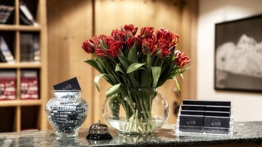 Rezeption mit Blumen und kleinen Gegenständen auf dem Empfangstresen zur Begrüßung von Gästen.