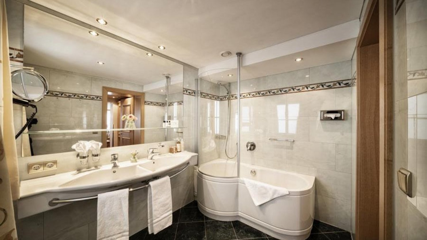 Luxury Modern Bathroom with Elegant Features A spacious modern bathroom with a curved bathtub, dual sinks, and stylish lighting fixtures
