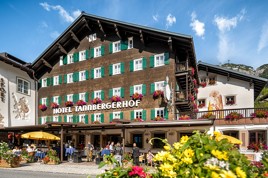 The Hotel Tannbergerhof in Lech with its flower-decorated facade and sunny terrace © Foto Lehmann