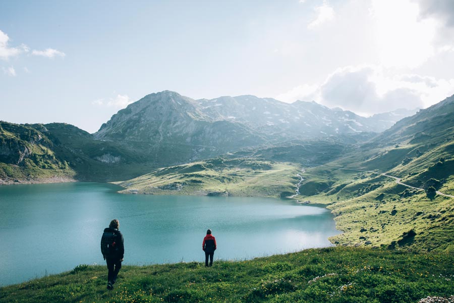 Zwei Wanderer blicken auf einen wunderschönen natürlichen Bergsee