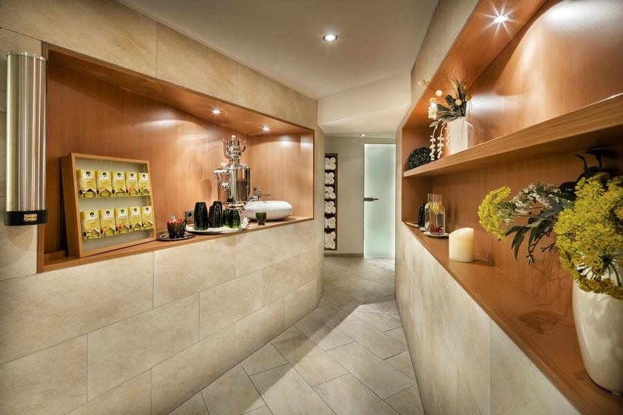 The relaxation area with decorative wooden shelves, drinks station and tiled walls at the Tannbergerhof in Lech © Foto Lehmann
