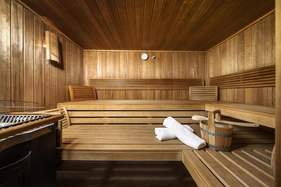 The wooden sauna with benches, infusion bucket, towels and sauna stove at the Tannbergerhof in Lech © Foto Lehmann